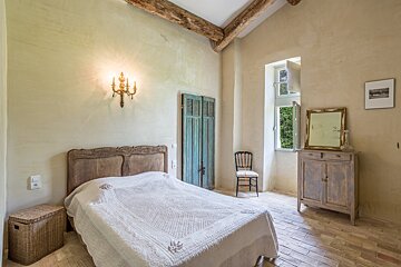 A bedroom with a bed a dresser and a mirror
