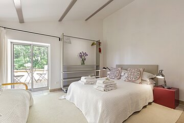 A bedroom with two beds and a sliding glass door