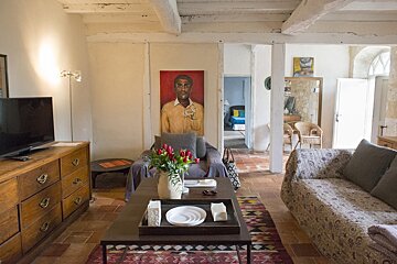 A living room with a painting of a man on the wall