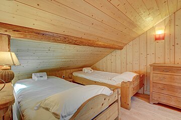 A bedroom with two twin beds and a dresser
