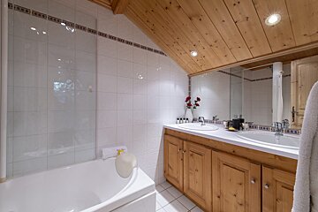 A bathroom with two sinks and a bathtub
