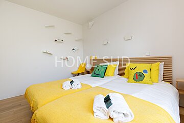 A bedroom with two beds and a sign that says home sud