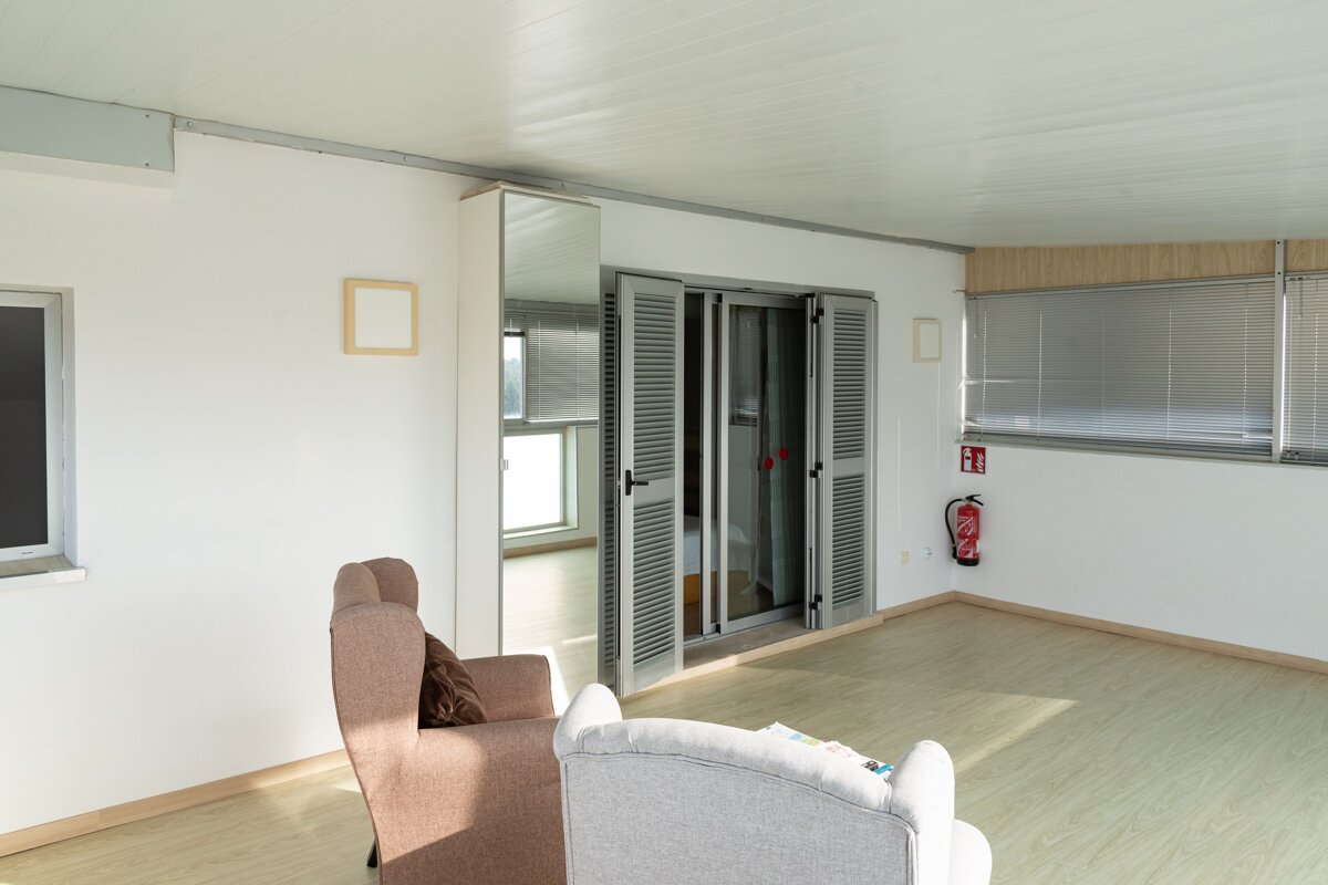 A room with a chair and a fire extinguisher on the wall