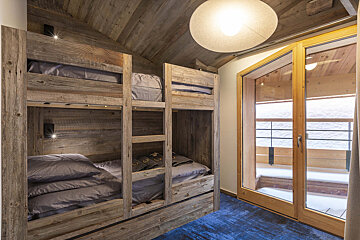 A room with bunk beds and a sliding glass door