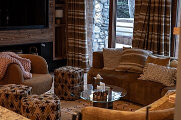 A living room with a brown couch and a glass coffee table