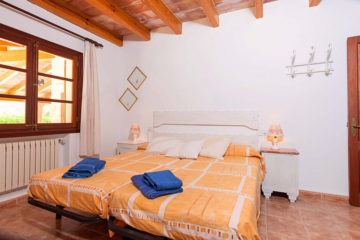 A bedroom with two beds and two lamps on the nightstands