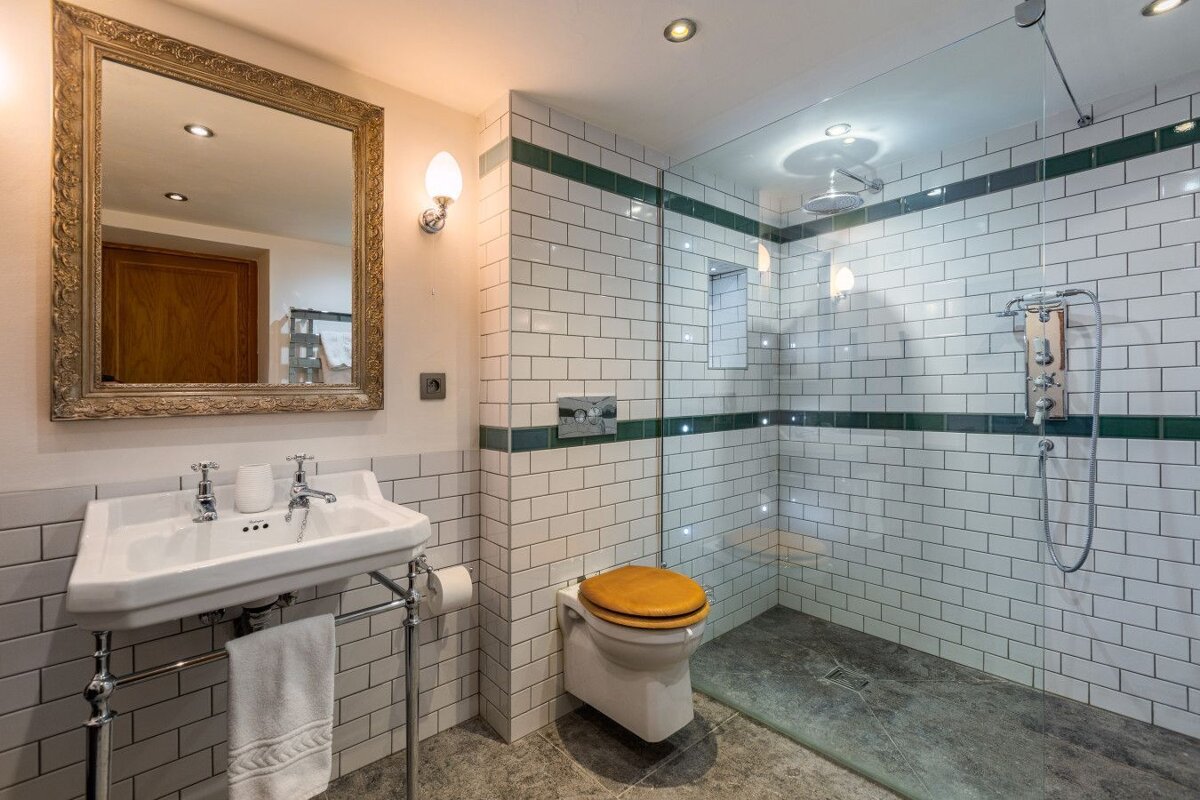 A bathroom with white subway tiles and a walk in shower