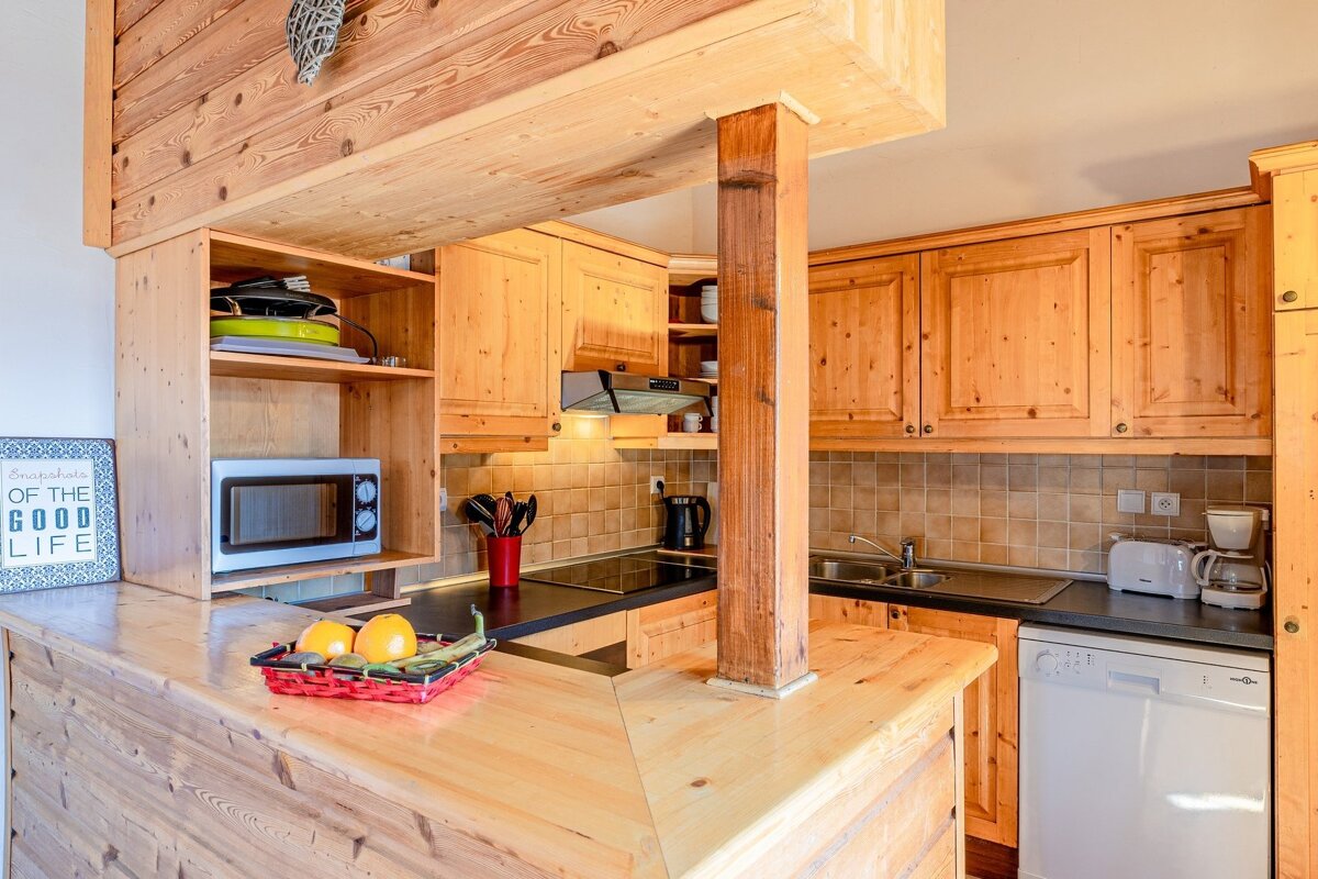 A kitchen with wooden cabinets and a sign that says 