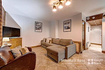 A living room with a couch and a chair and the words mountain base on the bottom