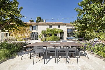 A large table and chairs in front of a house that says ' provence ' on it