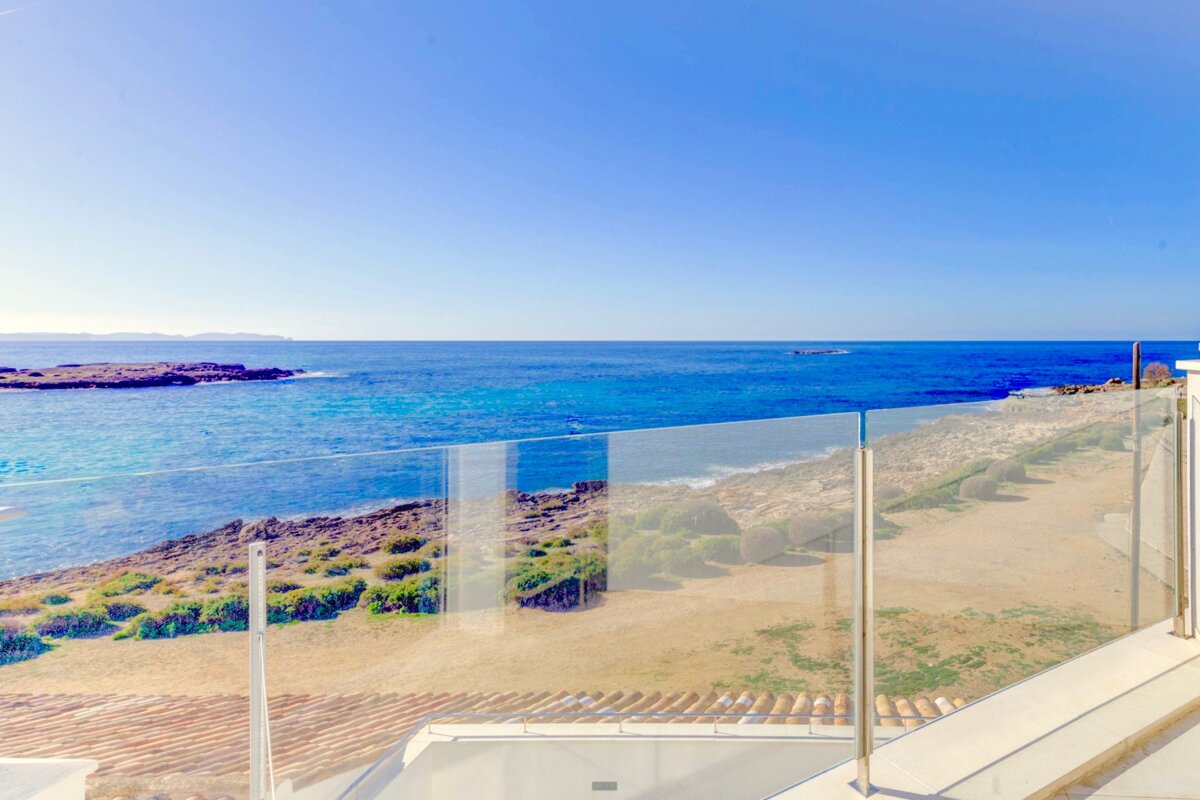 A view of the ocean from a balcony with a glass railing