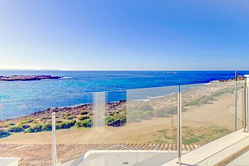 A view of the ocean from a balcony with a glass railing