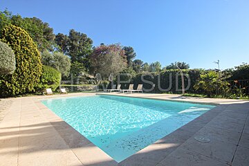 A large swimming pool surrounded by trees and a sign that says home sud