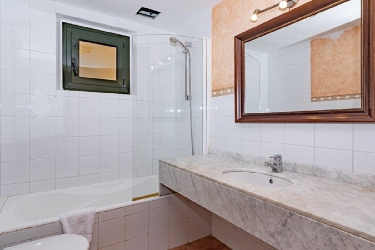 A bathroom with a sink a toilet and a shower