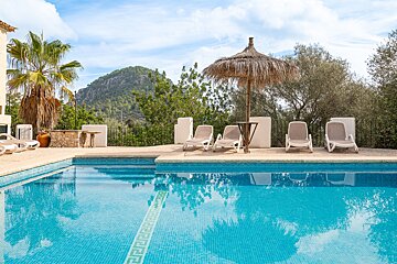 A swimming pool with chairs and umbrellas around it