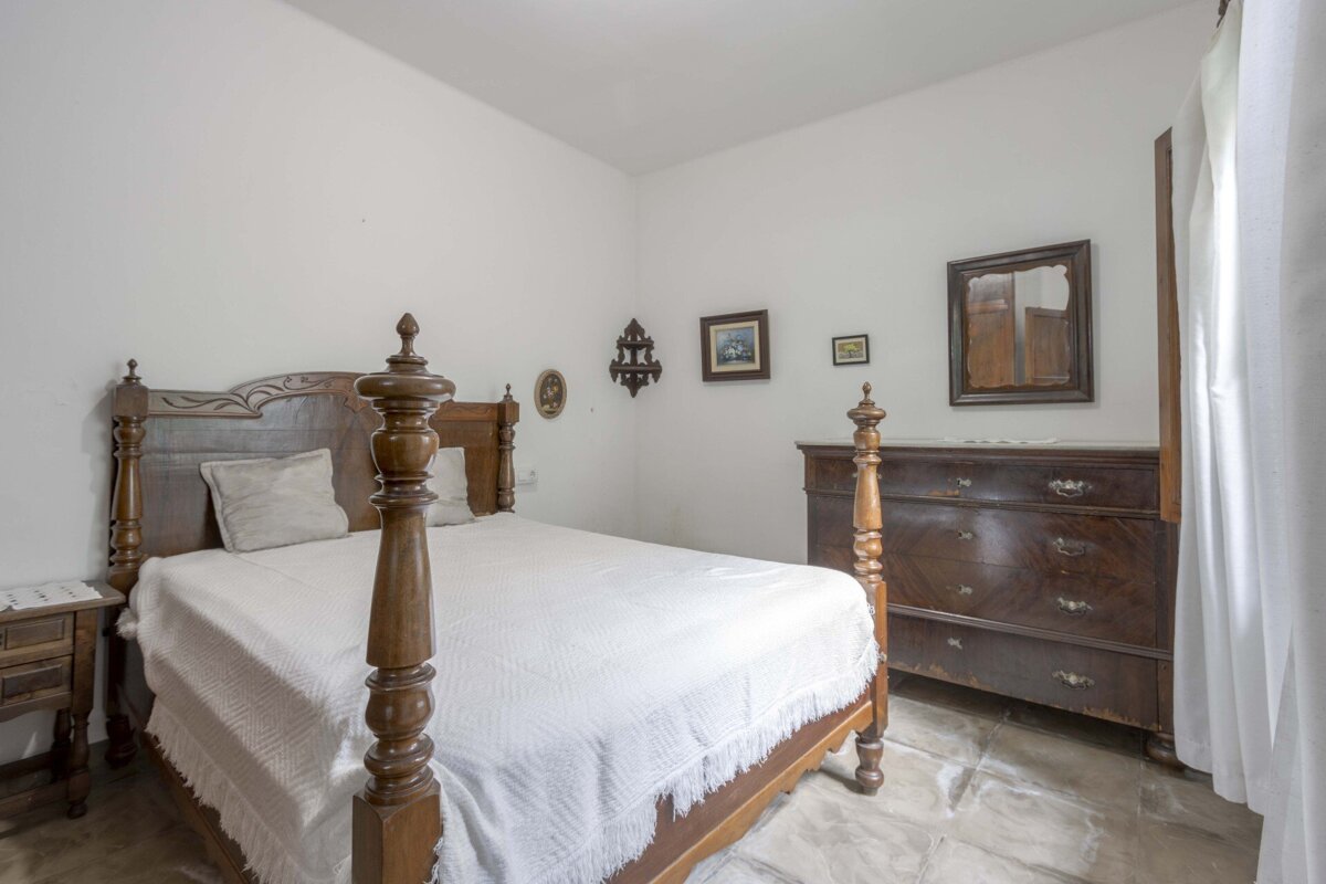 A bedroom with a four poster bed and a dresser
