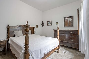 A bedroom with a four poster bed and a dresser