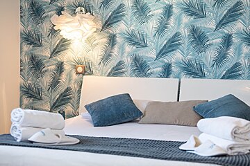A bed with blue pillows and white towels on it