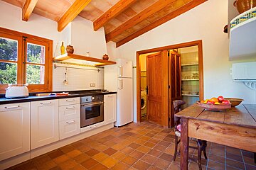 A kitchen with white cabinets and a wooden table