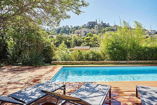 A swimming pool is surrounded by chairs and a sign that says immobilier