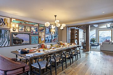 A dining room with a long table and chairs