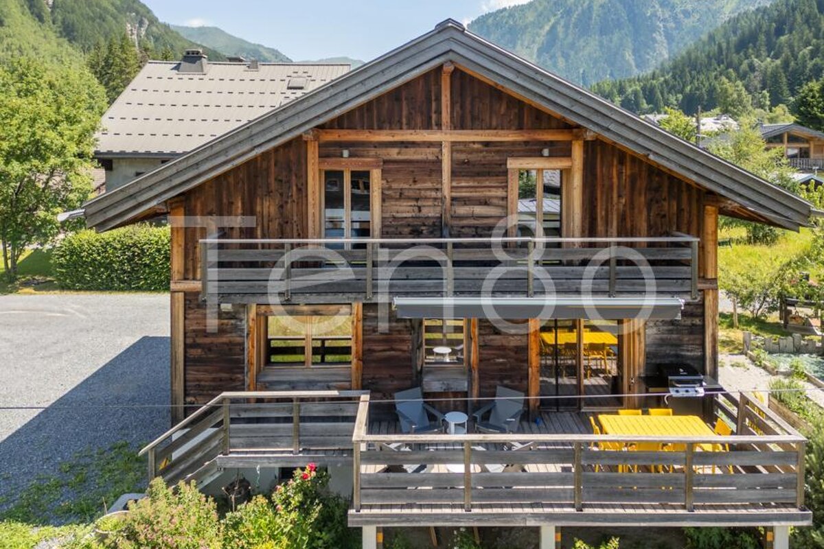 A large wooden house with a balcony and a sign that says tempo holidays