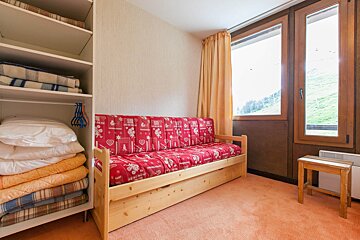A room with a couch and a window with a red couch that says ' montagne ' on it