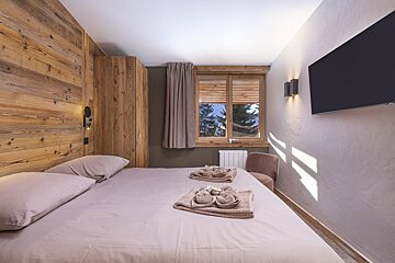 A bedroom with a large bed and a flat screen tv
