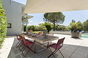 A patio with a table and chairs under an awning
