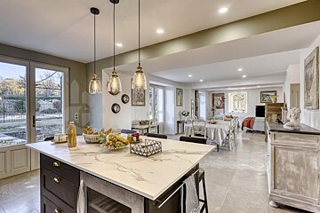 A kitchen with a large island and a marble counter top