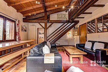 A living room with a couch and a table with the words mountain base on the bottom