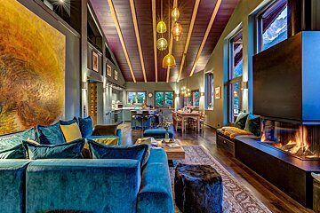 A living room with a blue couch and a fireplace