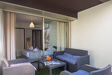 A hotel room with a couch and a table with a magazine on it