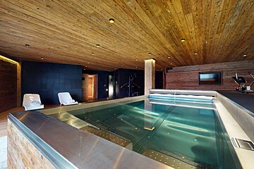 A large indoor swimming pool with a wooden ceiling