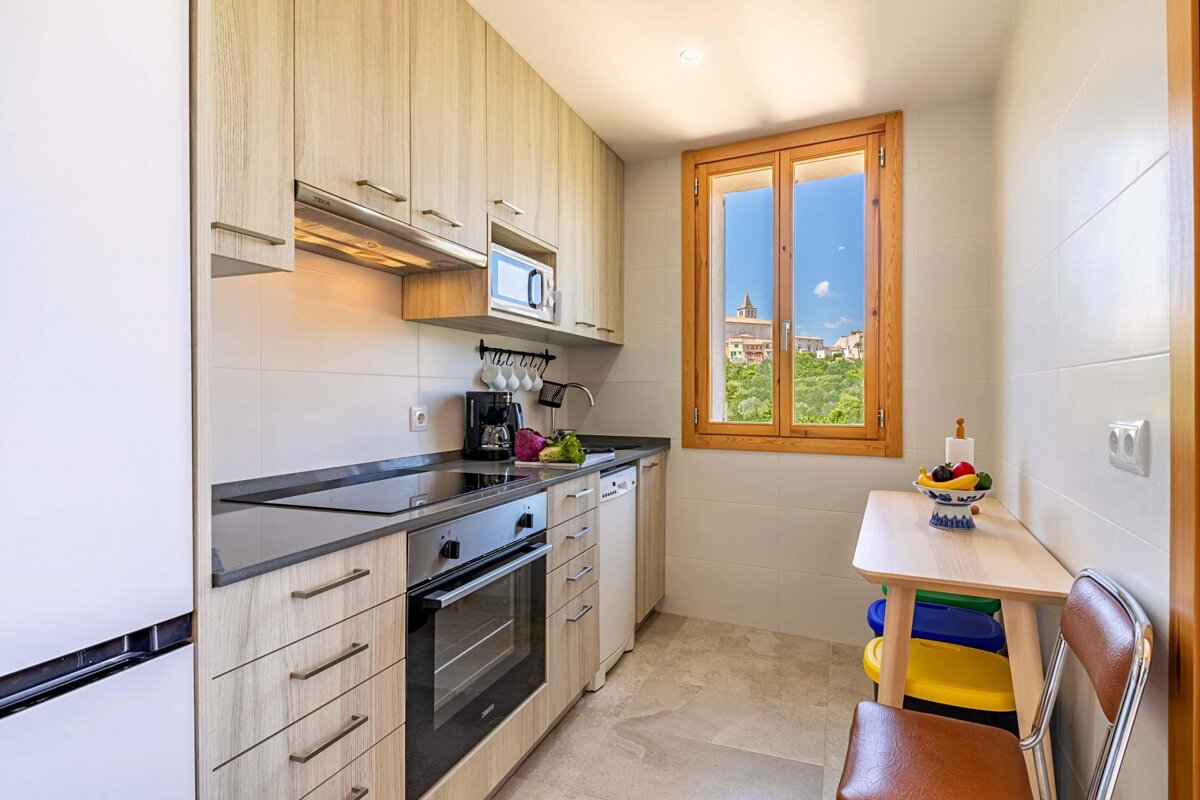 A kitchen with a table and chairs and a window