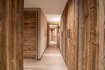 A hallway with wood paneling on the walls and doors
