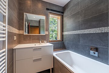 A bathroom with a sink and bathtub and a window