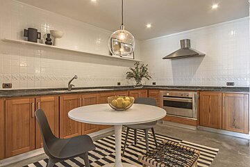 A kitchen with a bowl of lemons on the table