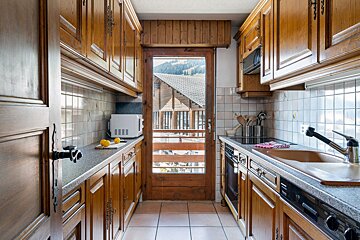 A kitchen with wooden cabinets and a stainless steel dishwasher