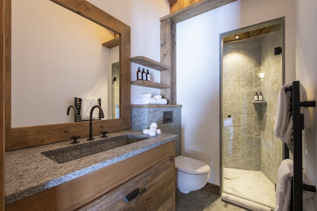 A bathroom with a toilet a sink and a mirror