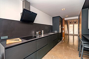 A kitchen with black cabinets and a stove top oven