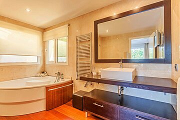 A bathroom with a tub and a sink and a mirror