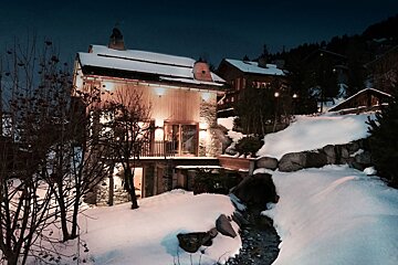 A snowy landscape with a house in the background