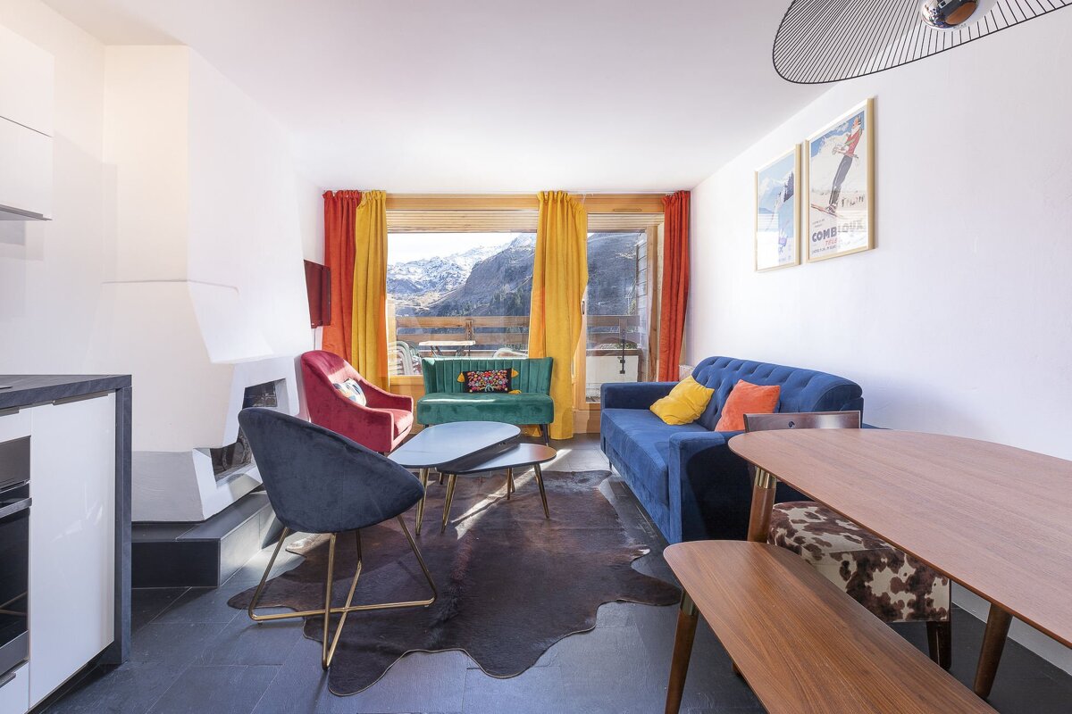 A living room with a blue couch and a yellow chair