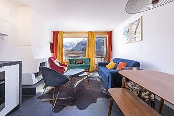 A living room with a blue couch and a yellow chair