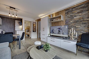 A living room with a flat screen tv showing a skier on it