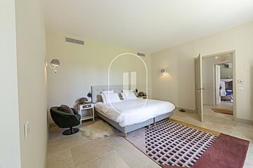 A bedroom with a large bed and a rug