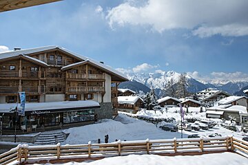 A ski center store in the snow with mountains in the background