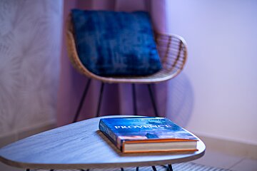 A book called provence sits on a table next to a chair