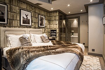 A bedroom with a bed with a fur blanket on it